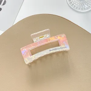 Detail of iridescent marble hair claw clip with Barrette La France gold text on acrylic
