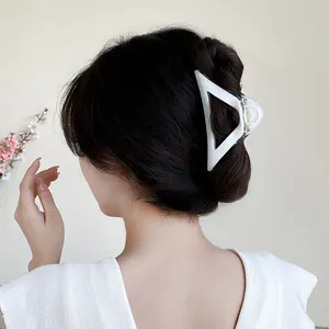 Elegant large triangle hollow hair claw clip in creamy white matte finish on model
