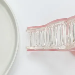 Detail of a large 13cm translucent pink acrylic hair claw clip with multi-tooth design