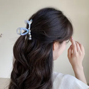 Pince à cheveux queue de poisson avec perles et strass bleu irisé sur les cheveux