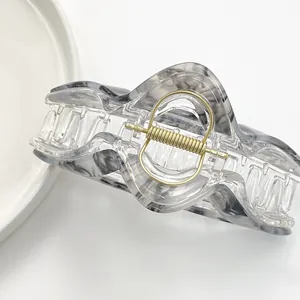 Large geometric hair claw clip with elegant marble pattern and golden spring
