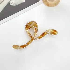 Detail view of 13cm tortoiseshell hair claw clip with S-curve design and glossy finish