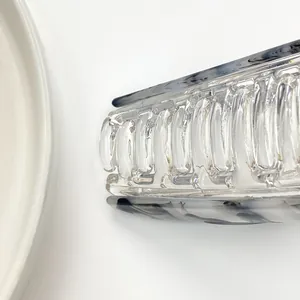 Close-up of geometric hair claw with marble texture and clear acrylic biting teeth
