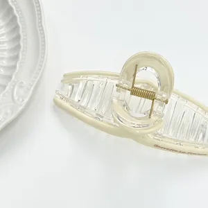 Detail of large beige hair claw clip with golden spring and Barrette La France lettering