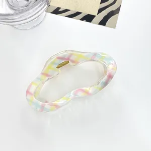 Foto macro de una pinza para el pelo con estampado de cuadros de colores sobre blanco
