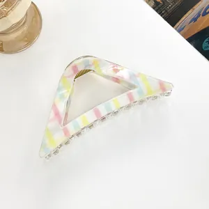 Macro detail of geometric hollow triangle hair claw clip with colorful macaron stripes