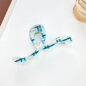 Macro shot of 13cm blue and white striped claw clip with visible gold metal spring