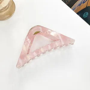 Detailed macro view of pink marble patterned triangular hair claw clip with metal spring