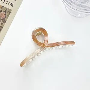 Detail of large marble texture hair claw clip with amber pattern and metal spring