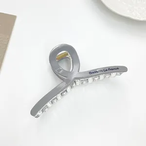 Detailed view of grey hair claw clip featuring Barrette La France text and metal spring