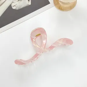 Detail of a large 13cm pale pink translucent hair claw with a sleek twisted design