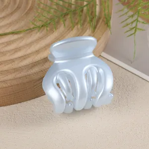 Close-up of light blue hair claw clip with pearlescent finish and smooth rounded teeth