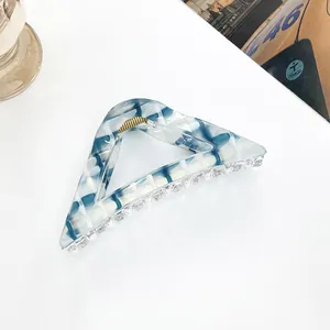Detail of blue marble pattern triangle hair claw clip with golden metal spring