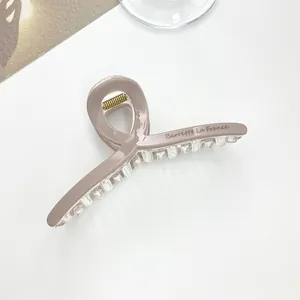 Detail of dusty pink hair claw clip with Barrette La France text and metal spring
