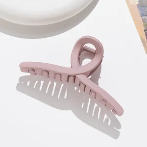 Vue détaillée d'une pince à cheveux torsadée rose lotus mate au design élégant et croisé