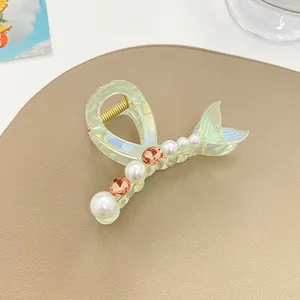 Détail d'une pince à cheveux sirène translucide avec perles et strass sur cuir