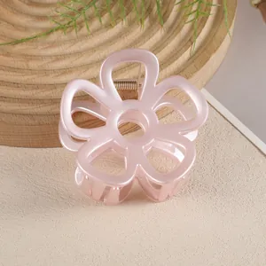 Détail de la pince à cheveux fleur rose évidée avec texture mate et ressort en métal