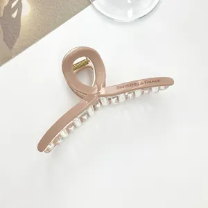 Detail view of pink resin hair claw clip with Barrette La France text on side