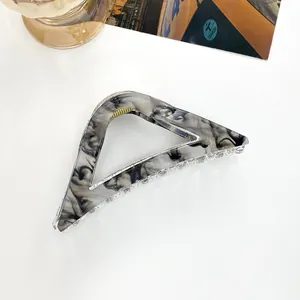 Detail shot of large hollow triangle hair claw with elegant marble pattern texture