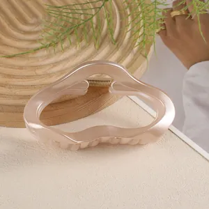 Détail de la pince à cheveux nuage 11cm en abricot nacré sur fond de bois naturel