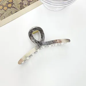 Close-up of marble texture acetate hair claw clip with strong golden metal spring