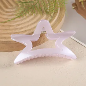 Détail macro de la pince à cheveux étoile creuse avec fini nacré et ressort en métal doré