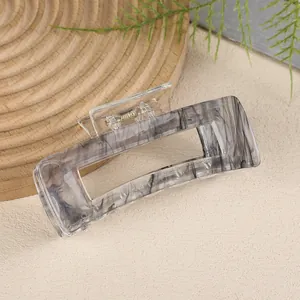 Minimalist transparent rectangle hair claw clip with black marble texture and gold metal spring