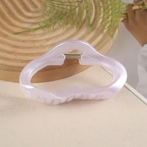 Vue détaillée d'une grande pince à cheveux rose nacré de 11cm au design ondulé