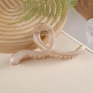 Détail d'une grande pince à cheveux perle champagne au design torsadé élégant pour cheveux