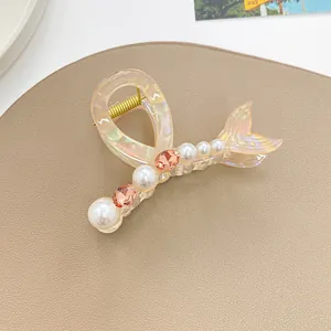 Détail d'une pince à cheveux en forme de queue de poisson avec perles et cristaux fins