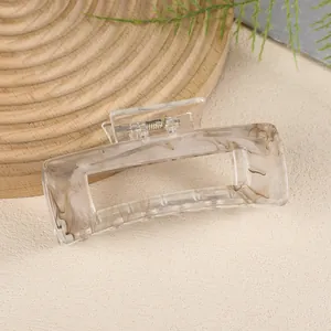 Detail of a rectangle hair claw clip with brown marble pattern and translucent finish