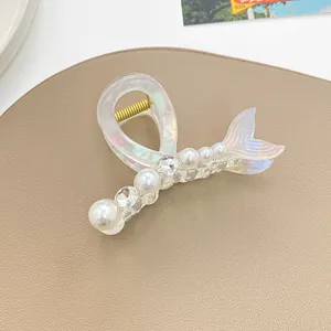 Gros plan sur la pince à cheveux sirène irisée avec perles blanches et strass brillants