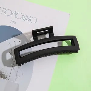 Grosse pince à cheveux carrée noir mat vue de près sur un fond de style minimaliste