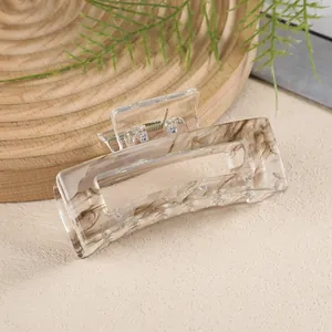 Close-up of rectangular marble pattern hair claw clip with strong gold metal spring