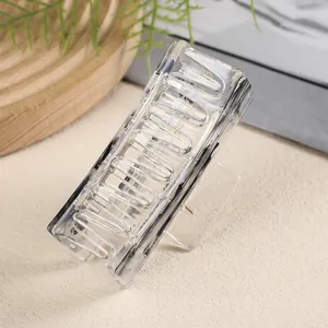 Macro detail of a medium transparent rectangular hair claw clip with silver metal spring