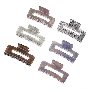 Set of six medium acetate hair claws in marble patterns and various colors on white background