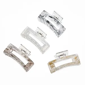 Close-up of four rectangular marble texture hair claws with strong metal springs