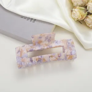 Vue macro d'une pince à cheveux rectangulaire avec motif marbré beige et violet