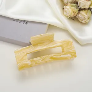 Détail de la pince à cheveux rectangulaire marbrée avec de la soie crème et des roses