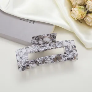 Détail d'une pince à cheveux rectangulaire à motif marbre sur soie et livre