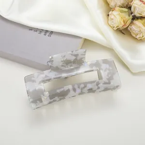 Détail macro d'une pince à cheveux rectangulaire avec motif marbre gris sur soie