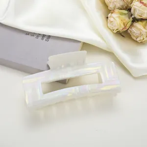 Gros plan sur une pince à cheveux rectangulaire crème avec texture nacrée géométrique