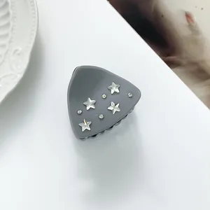 Macro shot of grey triangle hair claw clip with silver stars and rhinestones