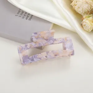 Detailed view of large marble texture acetate hair claw clip with purple floral patterns