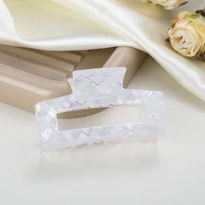 Primer plano de una pinza para el cabello blanco perlado con textura tejida elegante