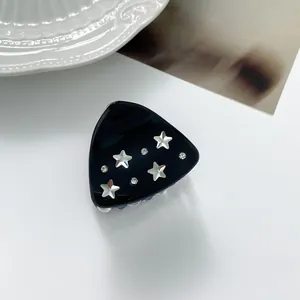 Detail of a black star hair claw clip with silver stars and sparkling rhinestones