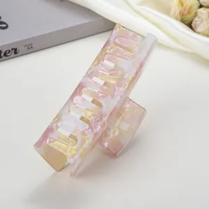 Dettaglio della pinza per capelli in acetato marmorizzato rosa e giallo lucido