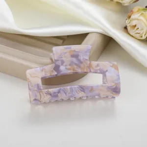 Primer plano de una pinza para el pelo de acetato jaspeado morado con diseño rectangular