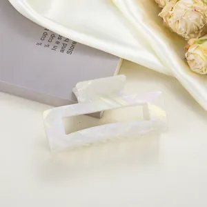 Close-up of a medium 8cm acetate hair claw clip with iridescent white floral texture