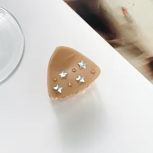 Detail of a khaki resin star hair claw clip with sparkling rhinestones and stars